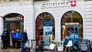 Polícias suíços asseguram a zona onde clientes fazem fila para comprar o novo relógio Royal Pop da Swatch e Audemars Piguet, em Genebra, a 16 de maio de 2026
