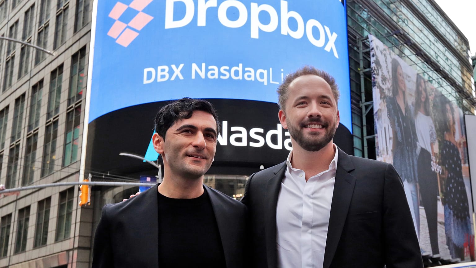 Dropbox co-founders Arash Ferdowski and Drew Houston pose for photos in New York's Times Square during the company's IPO, Mar. 2018