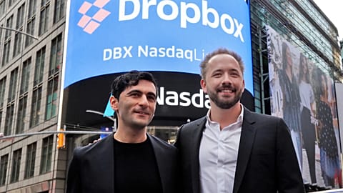 Dropbox co-founders Arash Ferdowski and Drew Houston pose for photos in New York's Times Square during the company's IPO, Mar. 2018