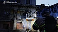 Rescue workers put out a fire of a residential building damaged after a Russian strike on Dnipro, 18 May, 2026