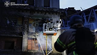 Equipas de salvamento apagam um incêndio num edifício residencial danificado após uma greve russa em Dnipro, 18 de maio de 2026