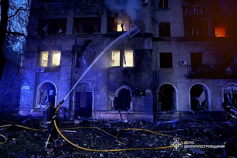 Rescue workers put out a fire of a residential building damaged after a Russian strike on Dnipro, 18 May, 2026