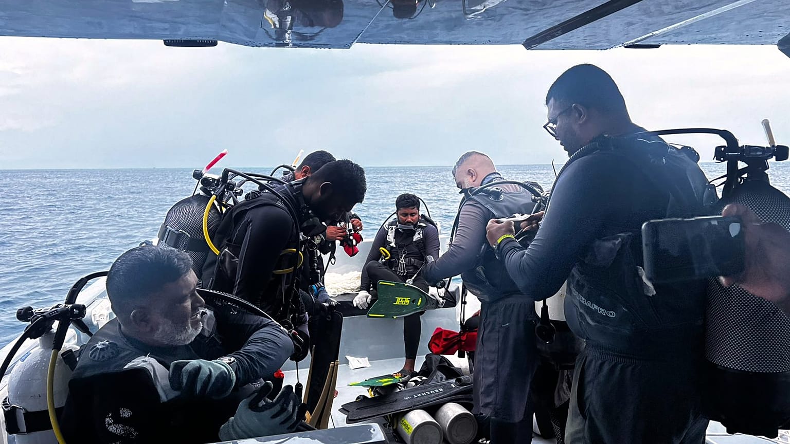 This image released by the Maldives President's Media Division, shows divers preparing to search for the four missing Italian divers near Alimathaa Island, Vaavu Atoll, Maldiv