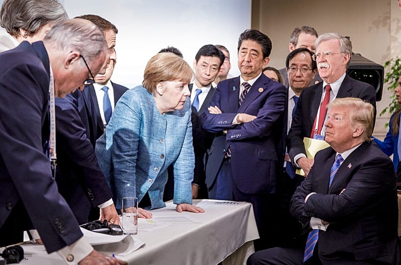 Angela Merkel speaks with US President Donald Trump during the G7 Leaders Summit in La Malbaie, Canada, June 9, 2018. (Jesco Denzel/German Federal Govt. via AP)