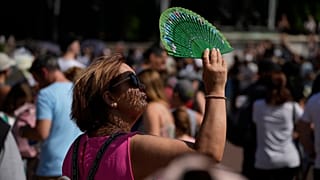 Una mujer usa un abanico para protegerse el rostro del sol en Londres durante la ola de calor del 18 de julio de 2022
