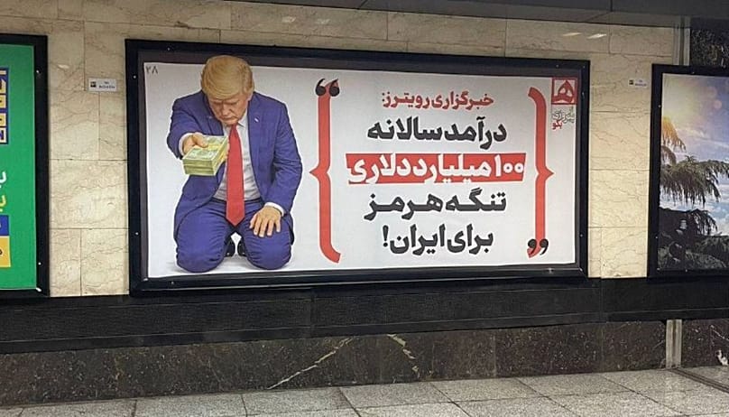 A billboard displayed in Tehran’s metro depicts Trump kneeling while handing money to Iran.  