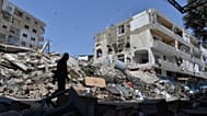 A man walks next to buildings destroyed in Israeli airstrikes the previous day in the southern village of Maarakeh, Lebanon, Sunday, May 17, 2026. 