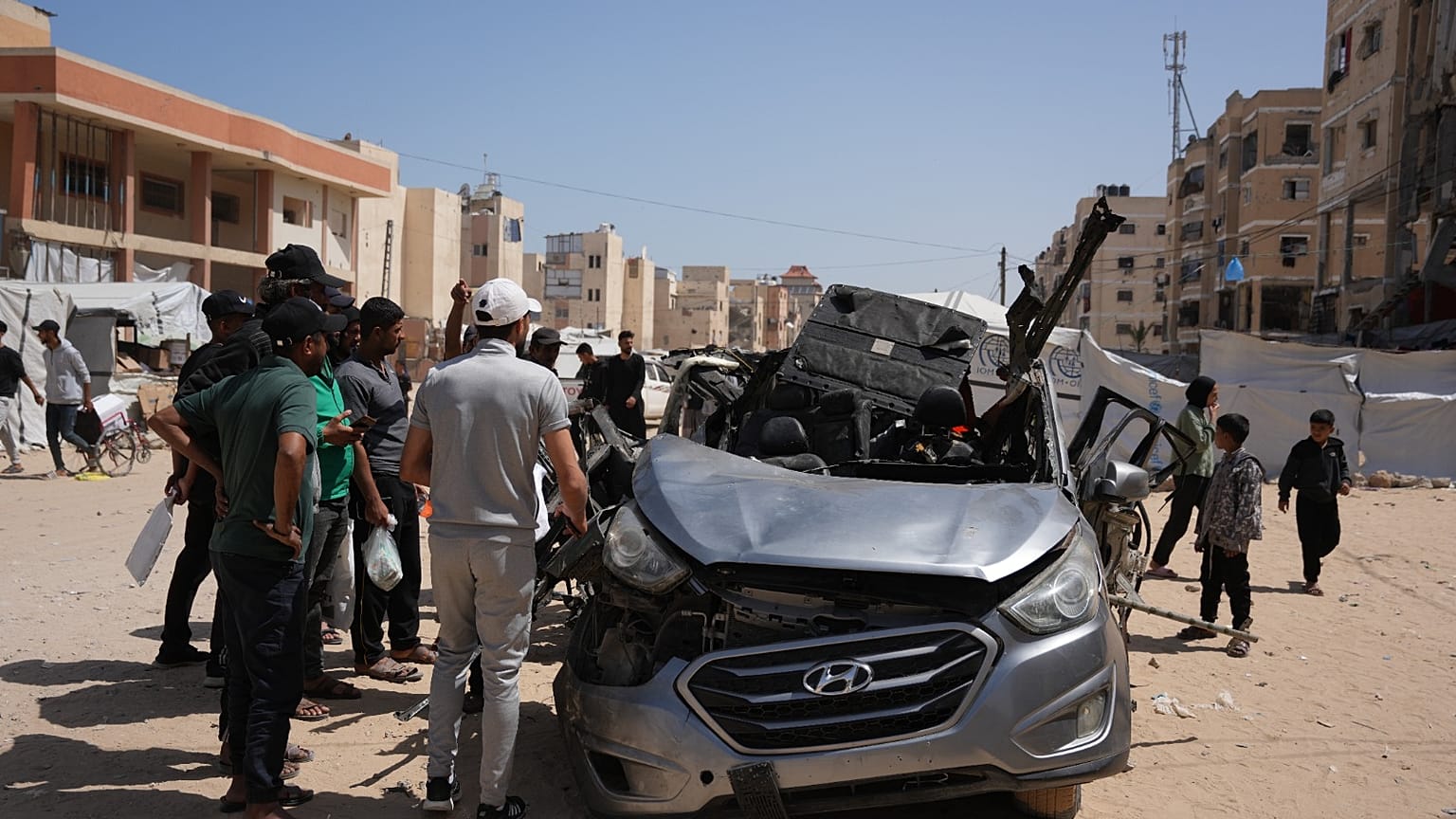 فلسطينيون يتفقدون سيارة تعرضت لغارة جوية إسرائيلية في خان يونس جنوب قطاع غزة، الأحد 10 مايو 2026.