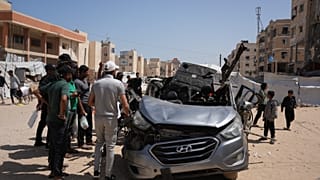 فلسطينيون يتفقدون سيارة تعرضت لغارة جوية إسرائيلية في خان يونس جنوب قطاع غزة، الأحد 10 مايو 2026.
