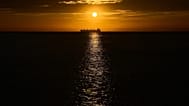 Un buque petrolero es visible en el mar Caribe al atardecer durante una conferencia cercana cuyo objetivo es la transición hacia fuentes de energía alternativas