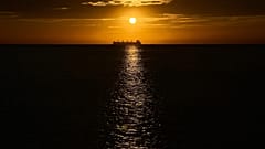 Um petroleiro é visível no Mar das Caraíbas ao pôr do sol, durante uma conferência próxima que visa a transição para fontes de energia alternativas.