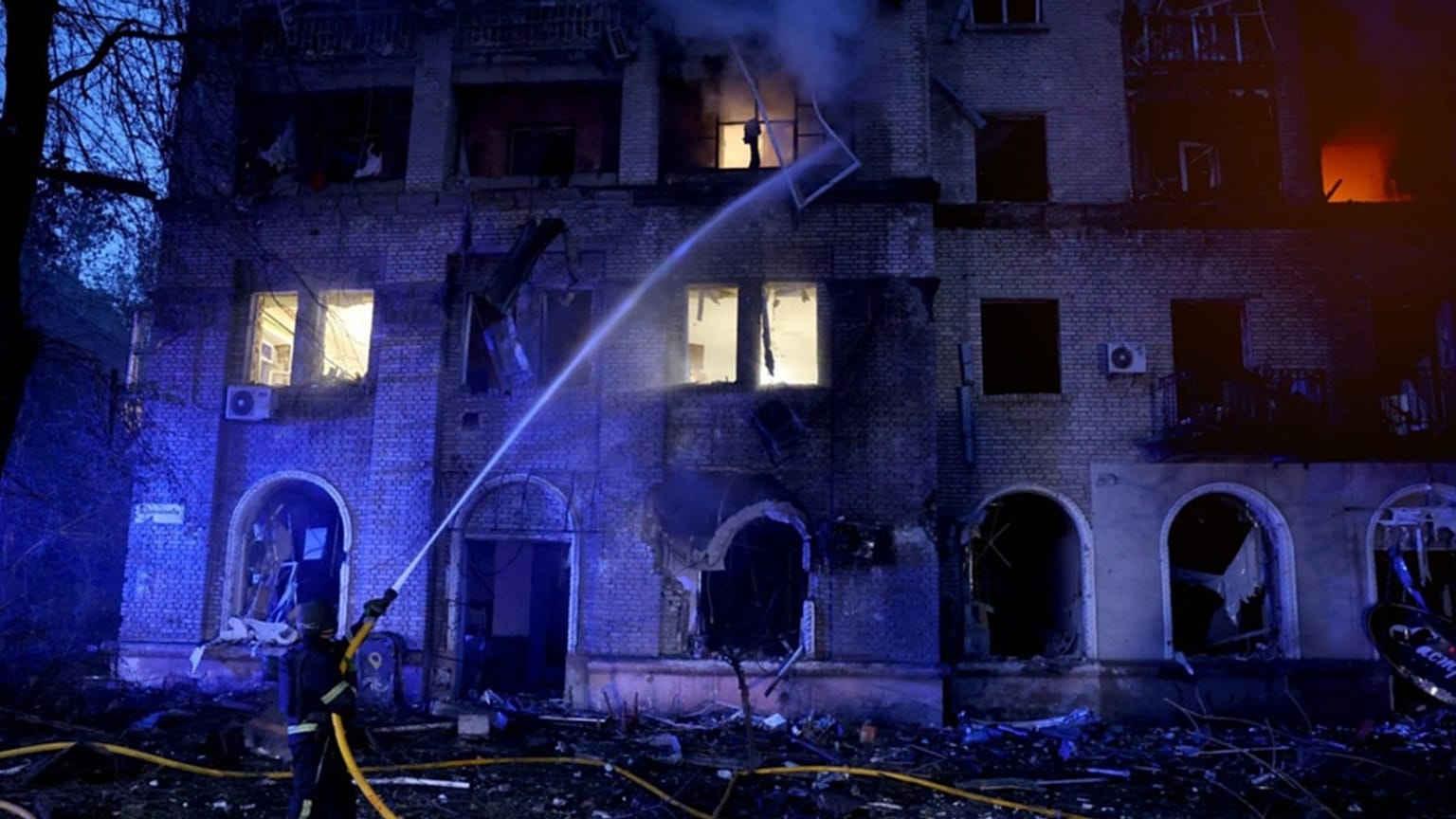A rescue worker puts out a fire of a residential building damaged after a Russian strike on Dnipro, Ukraine, on Monday, May 18, 2026, 