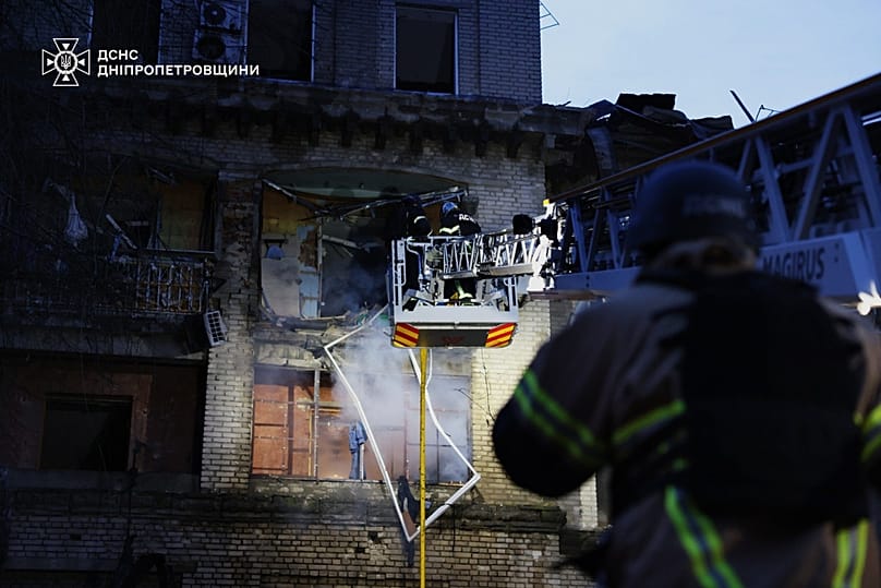 A rescue worker puts out a fire of a residential building damaged after a Russian strike on Dnipro, Ukraine, on Monday, May 18, 2026, 