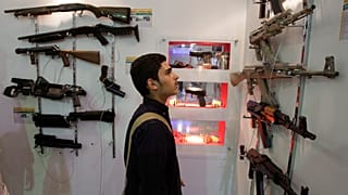 FILE: An Iranian man looks at guns as he visits a security equipment exhibition organised by the police at the Grand Mosque in Tehran, 24 September 2012