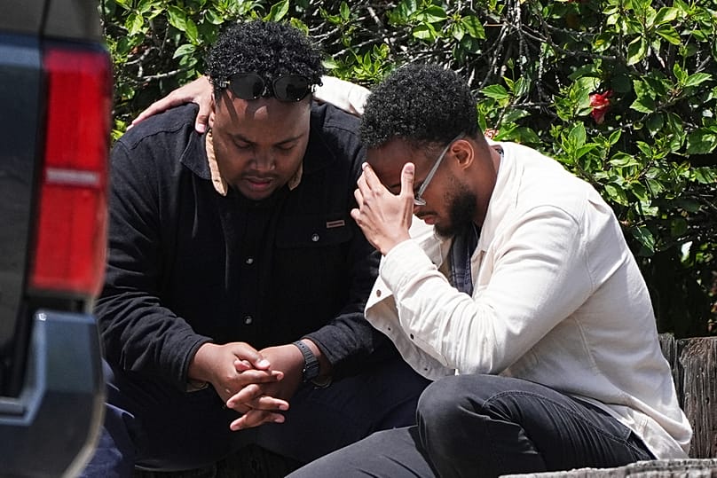 Two men embrace at the scene of a shooting outside the Islamic Center of San Diego Monday, May 18, 2026, in San Diego