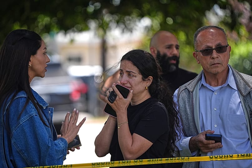People stand behind police tape at the scene of a shooting outside the Islamic Center of San Diego Monday, May 18, 2026, in San Diego