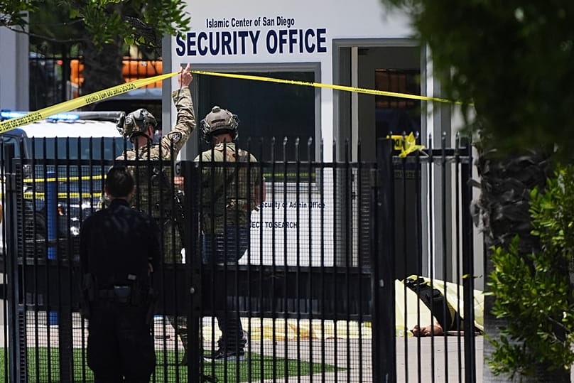 A body is covered with a tarp at the scene of a shooting outside the Islamic Center of San Diego Monday, May 18, 2026, in San Diego