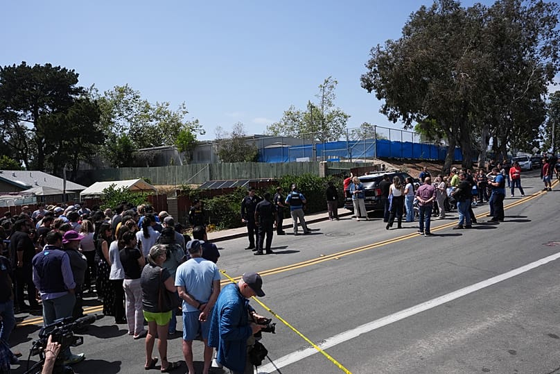 A crowd gathers near the scene of a shooting outside the Islamic Center of San Diego Monday, May 18, 2026, in San Diego