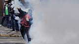 A protester returns a tear gas canister to police during an anti-government protest in La Paz, Bolivia, Monday, May 18, 2026.