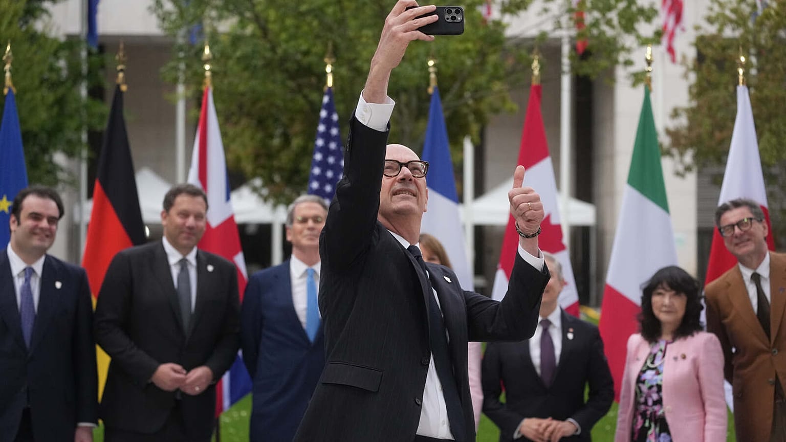 French Finance Minister Roland Lescure takes a selfie picture as G7 Finance Ministers and Central Bank Governors pose for a family photo at the G7 finance meeting in Paris