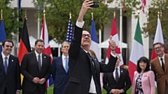 French Finance Minister Roland Lescure takes a selfie picture as G7 Finance Ministers and Central Bank Governors pose for a family photo at the G7 finance meeting in Paris