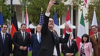 French Finance Minister Roland Lescure takes a selfie picture as G7 Finance Ministers and Central Bank Governors pose for a family photo at the G7 finance meeting in Paris