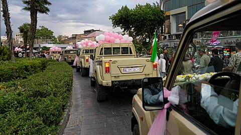 Newlyweds ride in pickup trucks during a mass wedding ceremony for the "Janfada" campaign in Tehran, Iran, Monday, May 18, 2026.