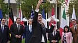 French Finance Minister Roland Lescure takes a selfie picture as G7 Finance Ministers and Central Bank Governors pose for a family photo at the G7 finance meeting in Paris