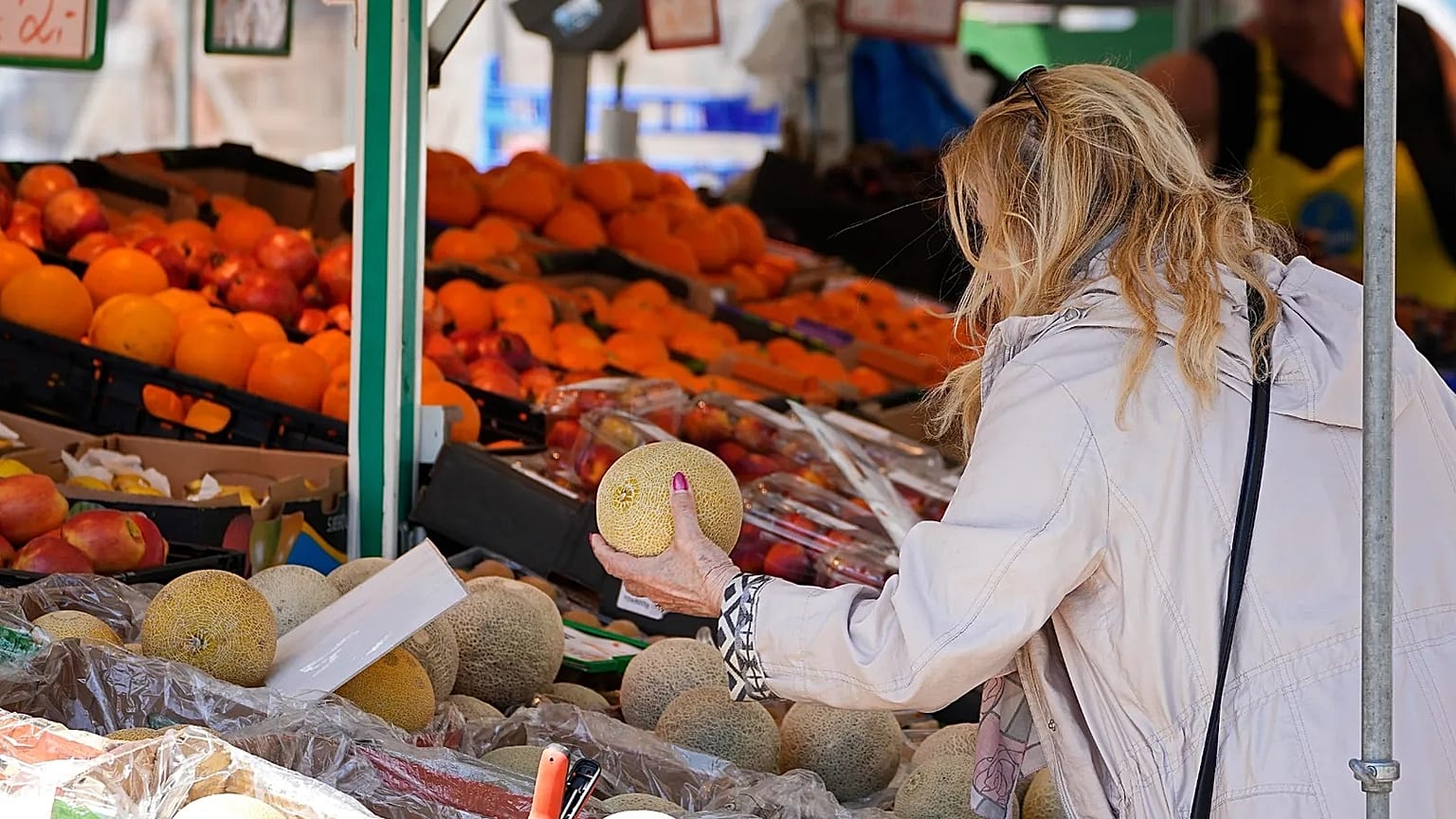 A woman checks the price of a water melon in Essen, amid high food inflation in Germany, May 2023. 