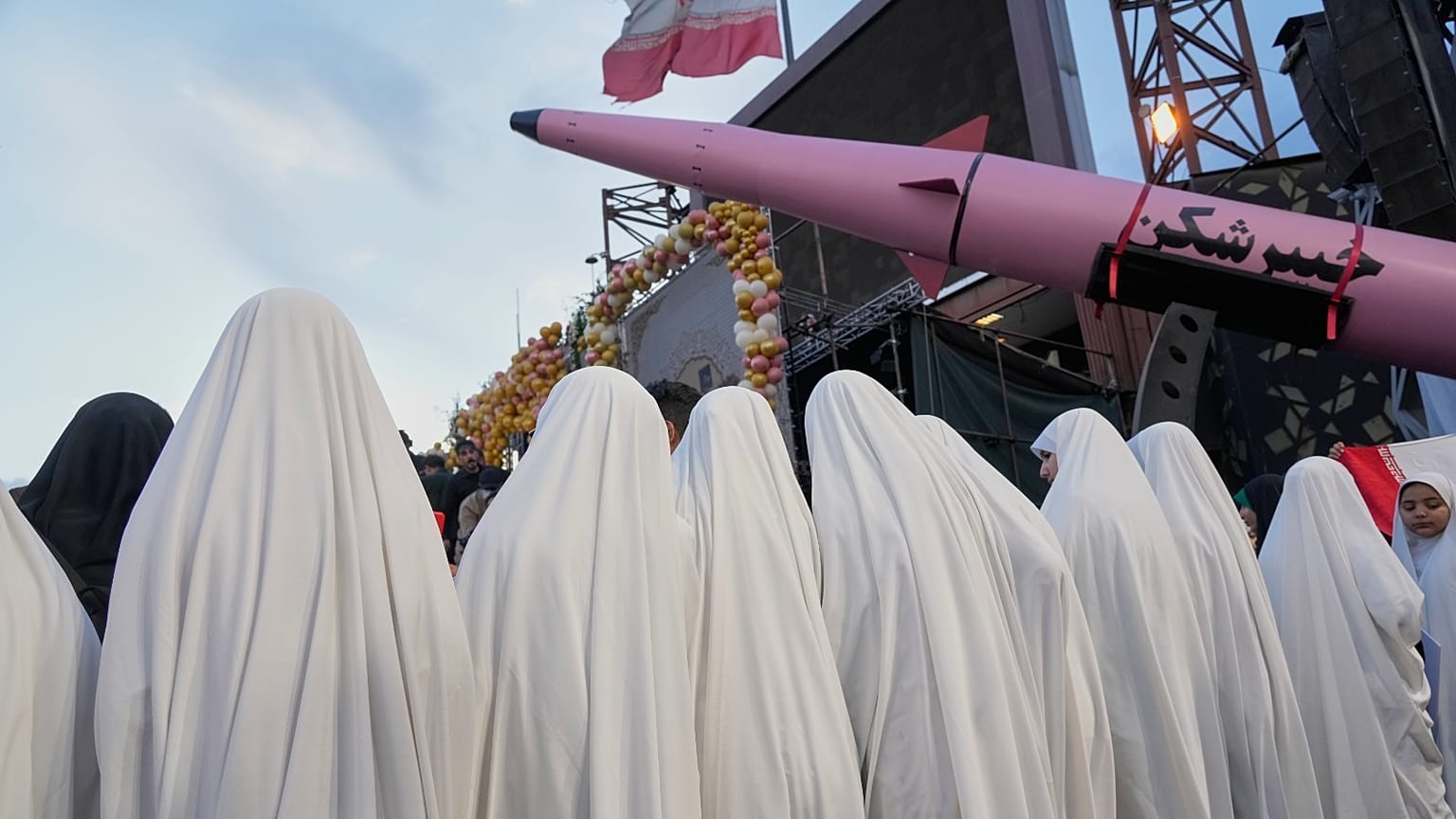 مجموعة من الفتيات يقفن بجانب صاروخ "خيبار باستر" خلال حفل زفاف جماعي للأزواج المشاركين في حملة ("التضحية من أجل إيران") الموالية للحكومة في طهران، إيران، 18 مايو 2026
