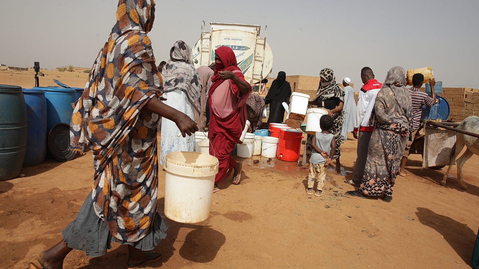 أشخاص يملأون حاويات المياه في نقطة توزيع مجانية وسط انقطاع المياه في الخرطوم، السودان، الاثنين 18 مايو 2026. (صورة AP/مروان علي)