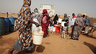 أشخاص يملأون حاويات المياه في نقطة توزيع مجانية وسط انقطاع المياه في الخرطوم، السودان، الاثنين 18 مايو 2026. (صورة AP/مروان علي)
