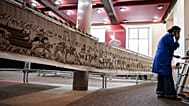 Funcionária consulta o telemóvel antes de começar a embalar a Tapeçaria de Bayeux, para a sua transferência para o British Museum, em Bayeux, a 18 de setembro de 2025.