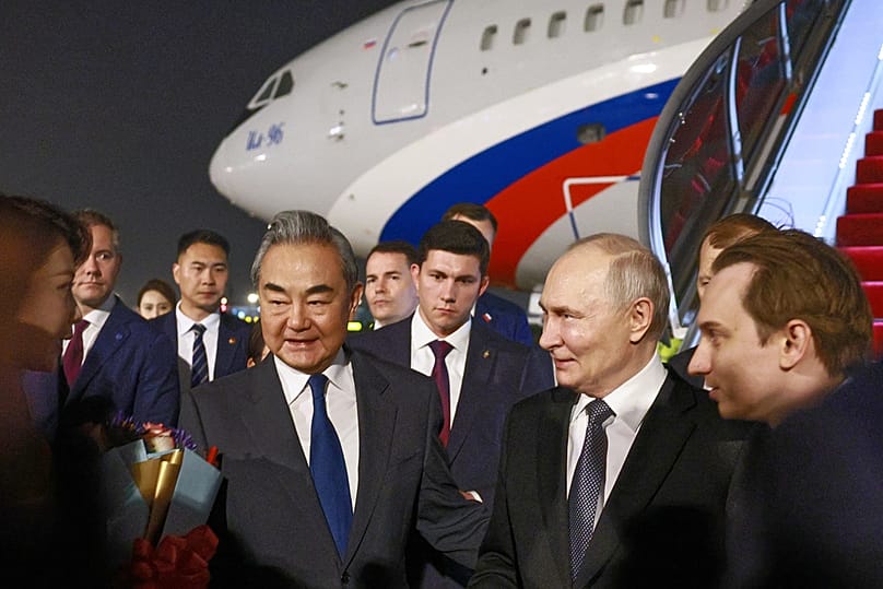 Russian President Vladimir Putin, center right, is greeted by China's Foreign Minister Wang Yi, center left, as he arrives in Beijing, Tuesday, May 19, 2026