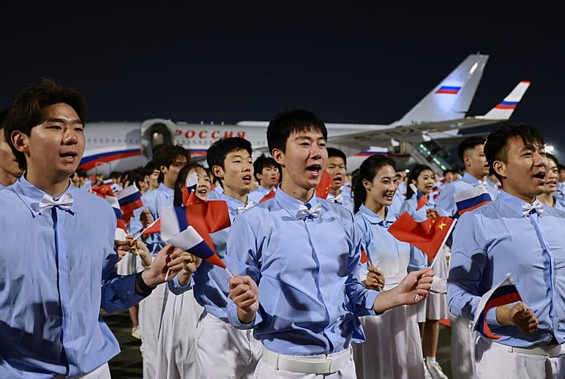 Chinese youth greet Russian President Vladimir Putin as he arrives in Beijing, Tuesday, May 19, 2026, for a two day visit to meet President Xi Jinping