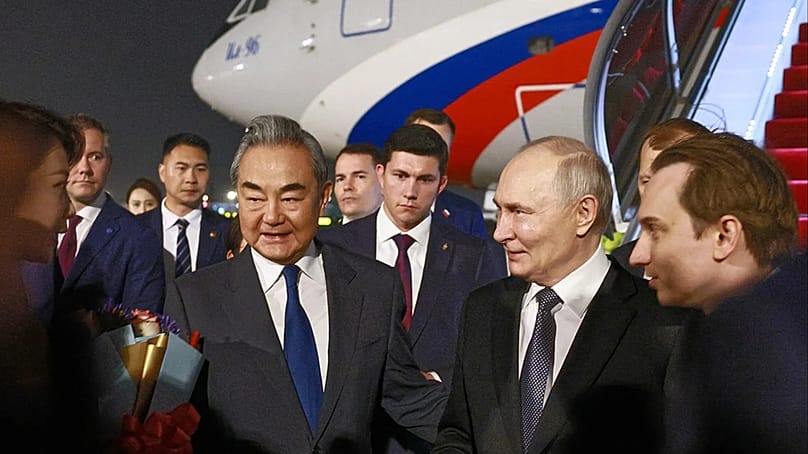 Russlands Präsident Wladimir Putin, Mitte rechts, wird bei seiner Ankunft in Peking am Dienstag, 19. Mai 2026, von Chinas Außenminister Wang Yi, Mitte links, begrüßt