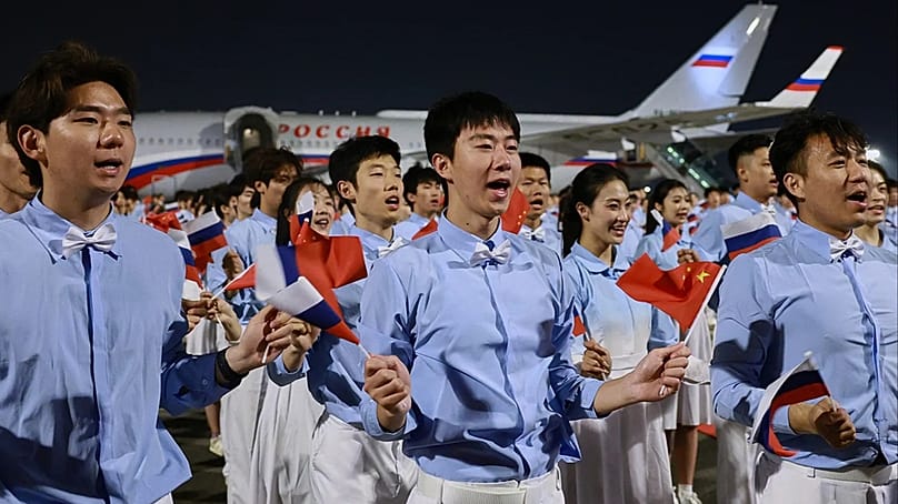 Chinesische Jugendliche begrüßen Russlands Präsidenten Wladimir Putin bei seiner Ankunft in Peking am Dienstag, 19. Mai 2026, zu einem zweitägigen Besuch bei Präsident Xi Jinping