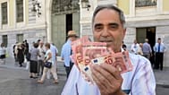 Archivo - El pensionista Giorgos Petropoulos muestra billetes de diez euros que recibe del Banco Nacional de Grecia en Atenas, el miércoles 1 de julio de 2015.