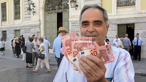 File - Pensioner Giorgos Petropoulos shows ten euros notes who receive from National Bank of Greece in Athens, Wednesday, 1 July 2015.
