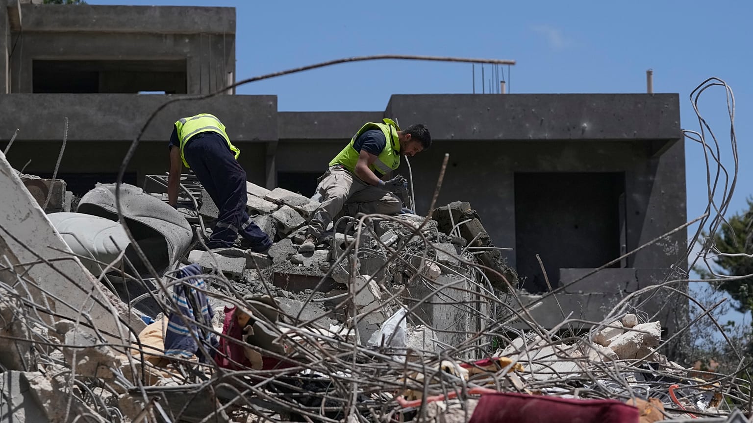 Equipa de salvamento procura vítimas entre os escombros de uma casa destruída por um ataque aéreo israelita na terça-feira