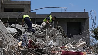 Equipa de salvamento procura vítimas entre os escombros de uma casa destruída por um ataque aéreo israelita na terça-feira