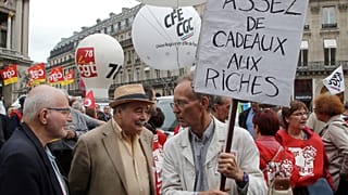 Un jubilado sostiene una pancarta en la que se lee «basta de regalos a los ricos» durante una protesta en París, Francia, el jueves 14 de junio de 2018.