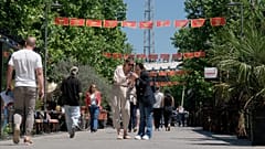 Pedestrians walk on a street decorated with national flags in Montenegro's capital Podgorica, Monday, May 18, 2026.