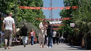 Pedestrians walk on a street decorated with national flags in Montenegro's capital Podgorica, Monday, May 18, 2026.