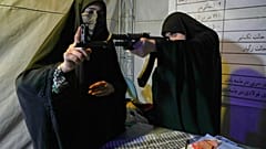 عنصر من قوات "الباسيج" التابعة للحرس الثوري الإيراني تقدّم إرشادات حول كيفية التعامل مع بندقية هجومية خلال حصة تدريب على السلاح في طهران، إيران، الثلاثاء 19 مايو/أيار 2026. 