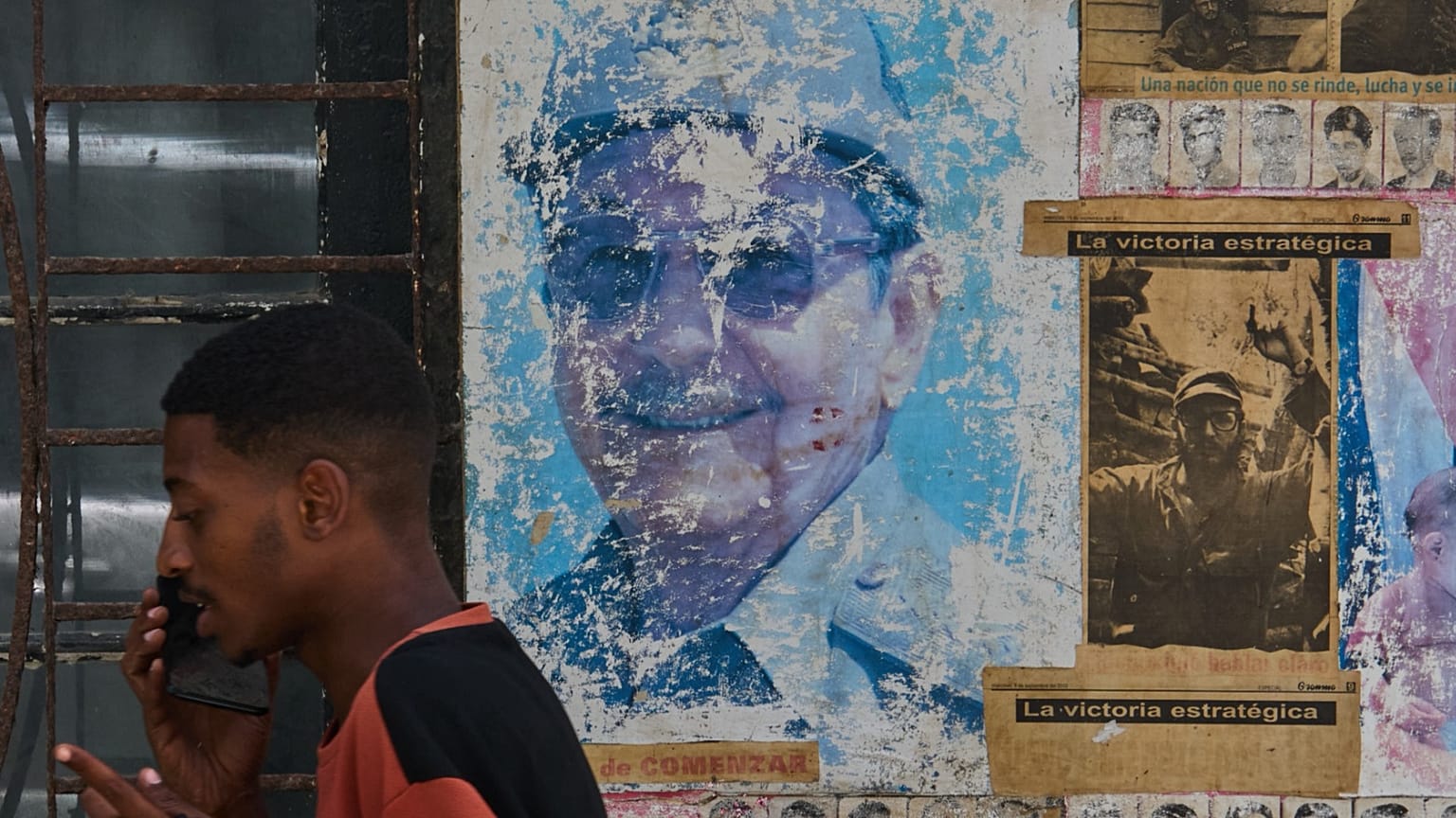 Un homme parle au téléphone près d’images de Raúl et Fidel Castro à La Havane, Cuba, mercredi 20 mai 2026.