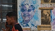 Un hombre habla por teléfono junto a imágenes de Raúl y Fidel Castro en La Habana, Cuba, el miércoles 20 de mayo de 2026.
