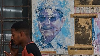 Un hombre habla por teléfono junto a imágenes de Raúl y Fidel Castro en La Habana, Cuba, el miércoles 20 de mayo de 2026.