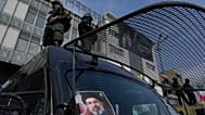 FILE: A poster of Ayatollah Mojtaba Khamenei is seen on an anti-riot police car as policemen stand on top during a rally to support him in Tehran, 9 March 2026