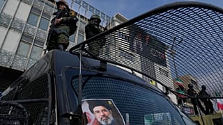 FILE: A poster of Ayatollah Mojtaba Khamenei is seen on an anti-riot police car as policemen stand on top during a rally to support him in Tehran, 9 March 2026